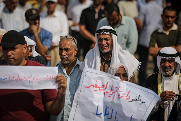 موظفون ولاجئون فلسطينيون يشاركون في مسيرة نظمها اتحاد الموظفين العرب بالأونروا من ساحة الكتيبة إلى المكتب الإقليمي للوكالة بمدينة غزة، للمطالبة بحماية حقوق العاملين واستمرار خدمات اللاجئين، 26 أكتوبر 2026. (تصوير: محمد صالحة)