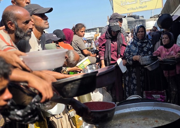 نازحون فلسطينيون يتلقون مساعدات غذائية من مطبخ خيري في مواصي خان يونس، جنوب قطاع غزة، 23 أكتوبر 2026. (تصوير: طارق محمد)