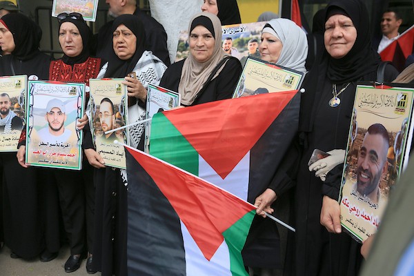 عائلات أسرى فلسطينيين ترفع صور أبنائها خلال وقفة في نابلس للمطالبة بالإفراج عنهم، وسط تحذيرات من تصاعد الانتهاكات بحق الأسرى والأسيرات في سجون الاحتلال. (تصوير: محمد ناصر)
