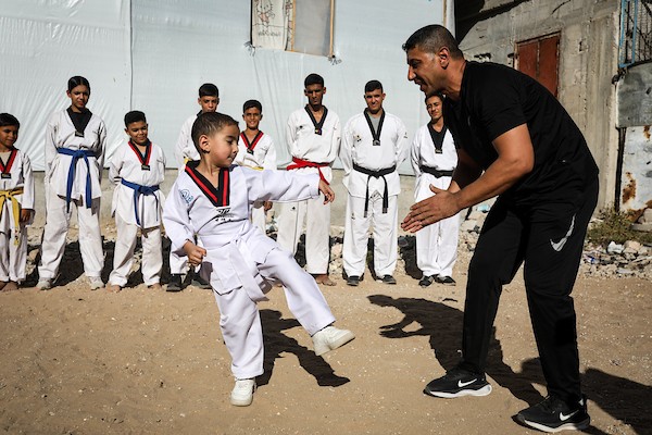أطفال فلسطينيون يتدربون على رياضة التايكوندو بالقرب من مبنى مدمر في مخيم النصيرات وسط قطاع غزة، في 8 أكتوبر/تشرين الأول 2026.تصوير: بلال أسامة