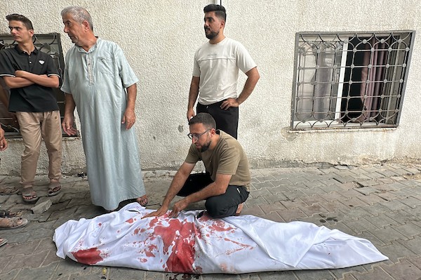 فلسطينيون ينوحون على رجل في مستشفى الشفاء بعد استشهاده في غارة جوية إسرائيلية استهدفت خيمة في مدينة غزة، في 2 أكتوبر/تشرين الأول 2026. صورة: هادي داود