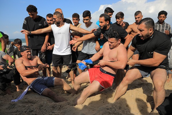 شبان فلسطينيون يمارسون تمارين وأنشطة رياضية على شاطئ النصيرات وسط قطاع غزة، يوم 16 أكتوبر/تشرين الأول 2026. (تصوير: حسن الجدي)