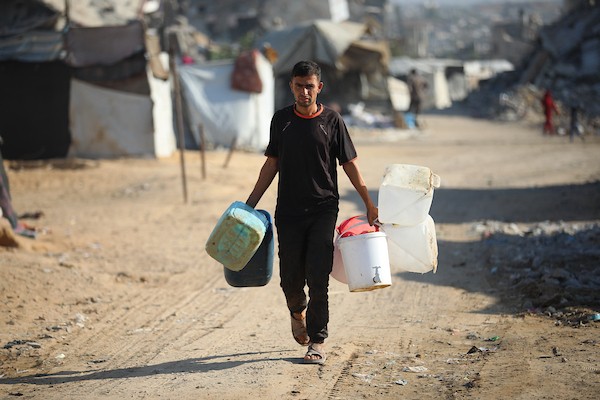 النصيرات – 18 أكتوبر/تشرين الأول 2026: أطفال وعائلات فلسطينية نازحة يتجمعون للحصول على المياه في مخيم النصيرات وسط قطاع غزة، وسط شح الإمدادات وتضرر البنية التحتية.تصوير: حسن الجدي