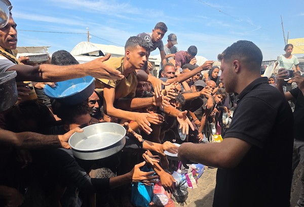 يتجمع فلسطينيون نازحون لتلقي وجبات ساخنة من مطبخ خيري، يُوصف بأنه آخر مطبخ عامل في منطقة المواصي بخان يونس، 2 أكتوبر/تشرين الأول 2026. (صورة: طارق محمد)