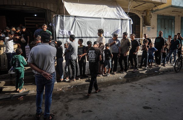 فلسطينيون ينتظرون الحصول على الخبز أمام مخبز في حي الدرج بمدينة غزة، وسط تحذيرات من توقف المخابز المتبقية بسبب نفاد الطحين، 22 أكتوبر 2026. (تصوير: محمد صالحة)