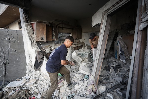 فلسطينيون يتفقدون ممتلكاتهم وسط أنقاض مبنى سكني استهدفته غارة جوية إسرائيلية في حي اليرموك بمدينة غزة، يوم 16 أكتوبر/تشرين الأول 2026. (تصوير: محمد صالحة)