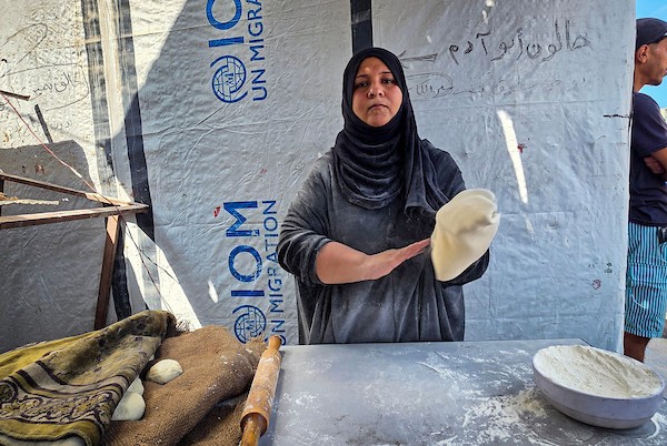 الفلسطيني مازن الدوش يُعدّ الخبز على صاج بدائي بين أنقاض المباني المدمرة في خان يونس، جنوب قطاع غزة، 9 تشرين الأول/أكتوبر 2026. (تصوير: طارق محمد)