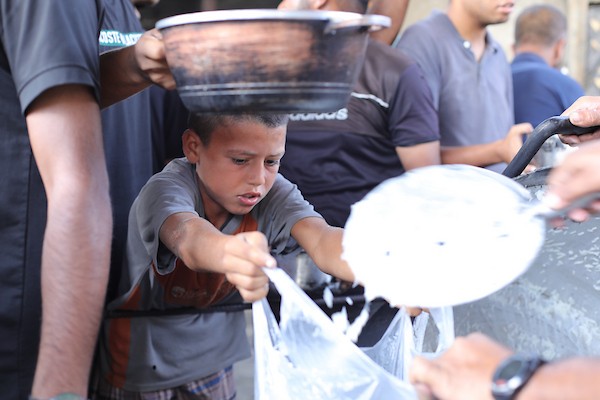 فلسطينيون نازحون يتجمعون للحصول على وجبات غذائية من مطبخ خيري في مخيم النصيرات وسط قطاع غزة، في 8 أكتوبر/تشرين الأول 2026.تصوير: حسن الجدي