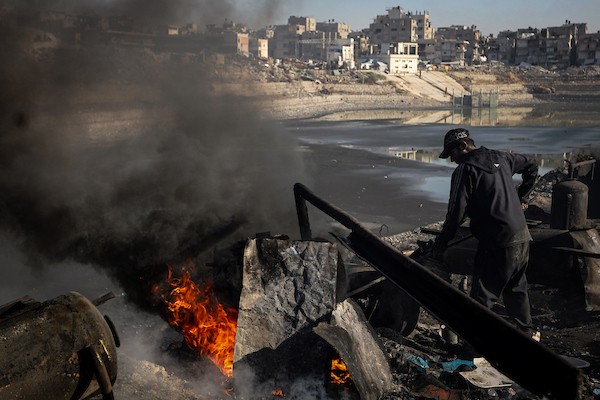 عمال فلسطينيون يجمعون ويفرزون النفايات البلاستيكية لإنتاج وقود بديل باستخدام أفران بدائية، في حي الشيخ رضوان شمال مدينة غزة، لمواجهة شح المحروقات الناجم عن الحصار الإسرائيلي، 29 أكتوبر 2026. (تصوير: محمد صالحة)