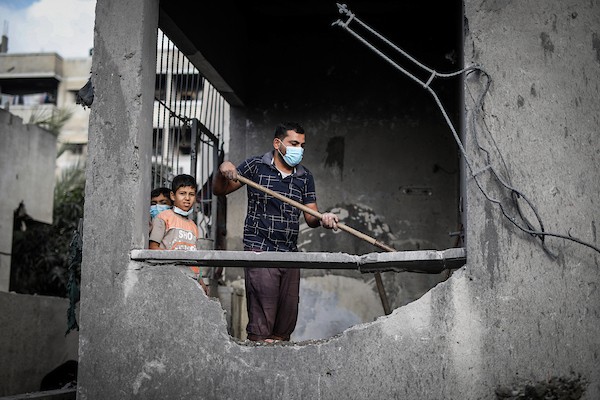 فلسطينيون يتفقدون ممتلكاتهم وسط أنقاض مبنى سكني استهدفته غارة جوية إسرائيلية في حي اليرموك بمدينة غزة، يوم 16 أكتوبر/تشرين الأول 2026. (تصوير: محمد صالحة)