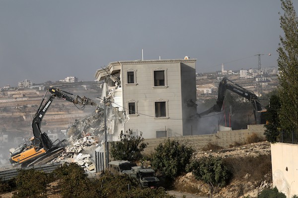 آليات الاحتلال الإسرائيلي تهدم منزلاً فلسطينياً في الخليل، وسط انتشار عسكري مكثف عقب استشهاد فلسطينيين اثنين، 23 أكتوبر 2026. (تصوير: مأمون وزواز)