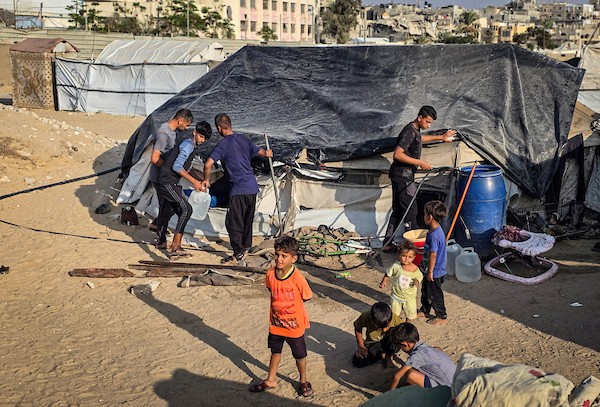 عائلات نازحة تقيم داخل خيام نُصبت بين القبور في إحدى مقابر خان يونس جنوبي قطاع غزة، في 14 أكتوبر/تشرين الأول 2026. (تصوير: طارق محمد)