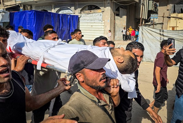 فلسطينيون يشيّعون جثمان الشاب محمد عليان البيوك، الذي استشهد إثر قصف إسرائيلي استهدف سطح مدرسة تؤوي نازحين في خان يونس جنوب قطاع غزة، 28 أكتوبر/تشرين الأول 2026. (تصوير: طارق محمد)