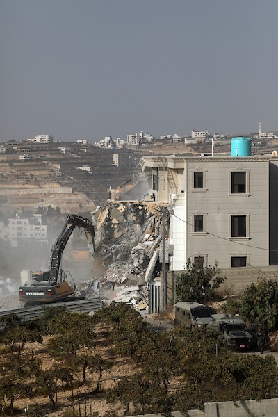 آليات الاحتلال الإسرائيلي تهدم منزلاً فلسطينياً في الخليل، وسط انتشار عسكري مكثف عقب استشهاد فلسطينيين اثنين، 23 أكتوبر 2026. (تصوير: مأمون وزواز)