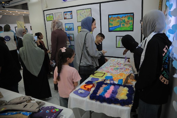 أيتام فقدوا آباءهم خلال الحرب يعرضون رسوماتهم وأعمالهم اليدوية في فعالية «بقيتُ لأروي... نجوتُ لأرسم»، بمخيم النصيرات وسط القطاع، 11 أكتوبر/تشرين الأول 2026. (تصوير: حسن الجدي)