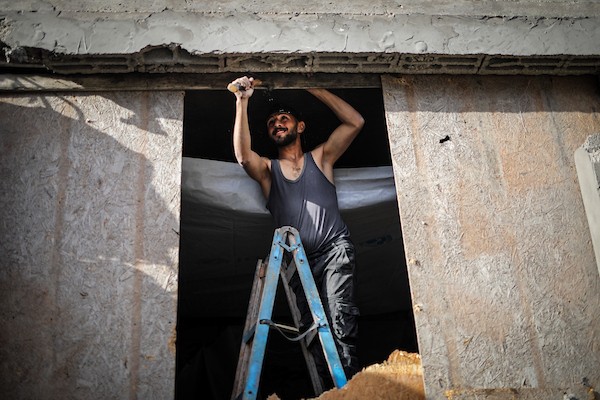 فلسطينيون يتفقدون ممتلكاتهم وسط أنقاض مبنى سكني استهدفته غارة جوية إسرائيلية في حي اليرموك بمدينة غزة، يوم 16 أكتوبر/تشرين الأول 2026. (تصوير: محمد صالحة)