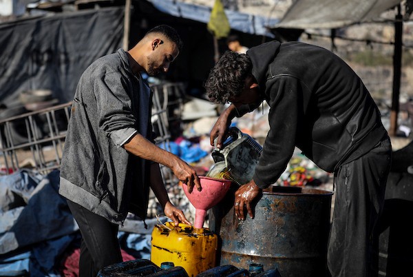 عمال فلسطينيون يجمعون ويفرزون النفايات البلاستيكية لإنتاج وقود بديل باستخدام أفران بدائية، في حي الشيخ رضوان شمال مدينة غزة، لمواجهة شح المحروقات الناجم عن الحصار الإسرائيلي، 29 أكتوبر 2026. (تصوير: محمد صالحة)