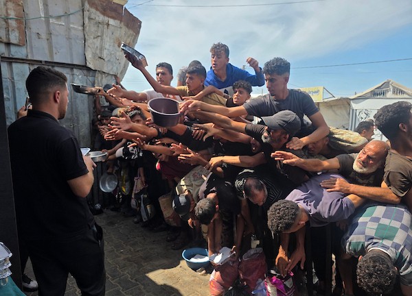 يتجمع فلسطينيون نازحون لتلقي وجبات ساخنة من مطبخ خيري، يُوصف بأنه آخر مطبخ عامل في منطقة المواصي بخان يونس، 2 أكتوبر/تشرين الأول 2026. (صورة: طارق محمد)