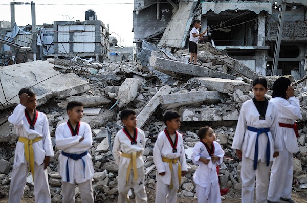 أطفال فلسطينيون يتدربون على رياضة التايكوندو بالقرب من مبنى مدمر في مخيم النصيرات وسط قطاع غزة، في 8 أكتوبر/تشرين الأول 2026.تصوير: بلال أسامة