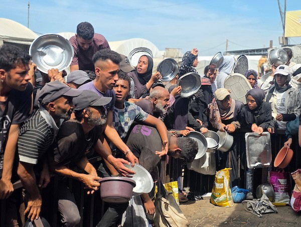 يتجمع فلسطينيون نازحون لتلقي وجبات ساخنة من مطبخ خيري، يُوصف بأنه آخر مطبخ عامل في منطقة المواصي بخان يونس، 2 أكتوبر/تشرين الأول 2026. (صورة: طارق محمد)