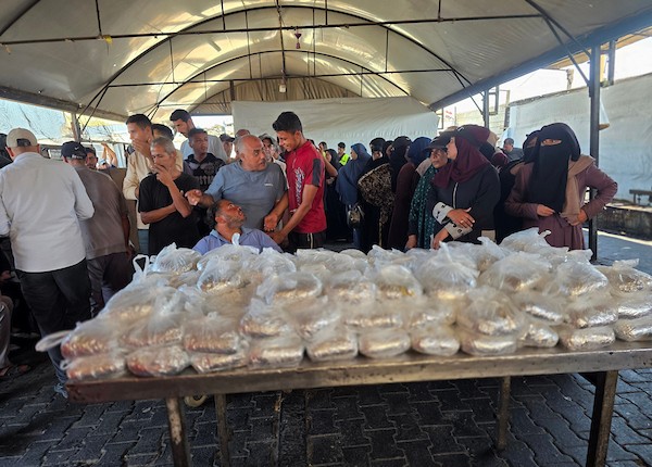 نازحون فلسطينيون يتلقون مساعدات غذائية من مطبخ خيري في مواصي خان يونس، جنوب قطاع غزة، 23 أكتوبر 2026. (تصوير: طارق محمد)