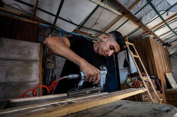 نجارون فلسطينيون يحولون صناديق المساعدات الخشبية إلى مقاعد مدرسية بمدينة غزة، في محاولة لدعم تعليم الأطفال وسط الدمار ونقص المواد الأساسية. (تصوير: محمد صالحة)