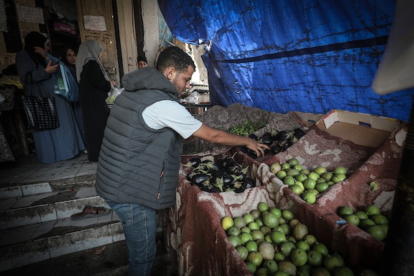 باعة فلسطينيون ومواطنون يقفون أمام أكشاك شبه خالية من الخضراوات والفواكه في أحد أسواق مخيم النصيرات وسط قطاع غزة، الخميس 22 أكتوبر 2026. تصوير: معز صالحي