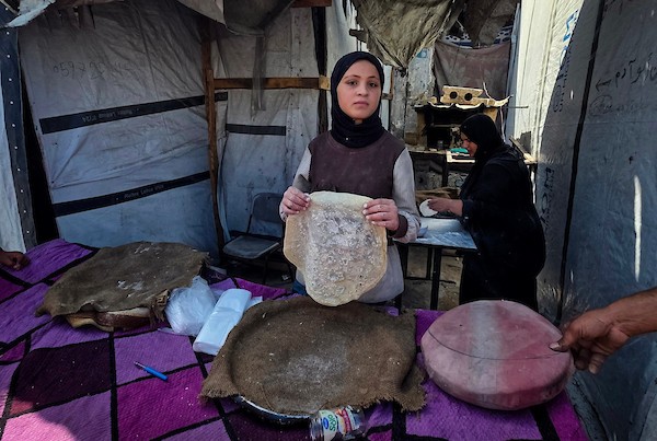 الفلسطيني مازن الدوش يُعدّ الخبز على صاج بدائي بين أنقاض المباني المدمرة في خان يونس، جنوب قطاع غزة، 9 تشرين الأول/أكتوبر 2026. (تصوير: طارق محمد)