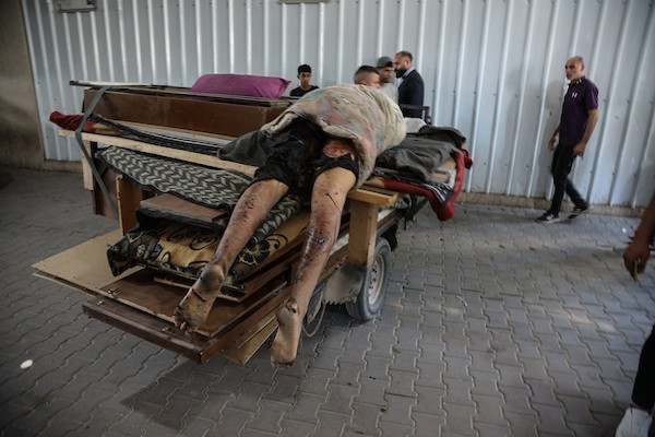 فلسطينيون ينقلون جثمان رجل إلى مستشفى العودة بمخيم النصيرات وسط قطاع غزة، بعد مقتله في غارة إسرائيلية استهدفت مركبة «توك توك» قرب جسر وادي غزة شمال المخيم، 20 أكتوبر/تشرين الأول 2026.تصوير: حسن الجدي