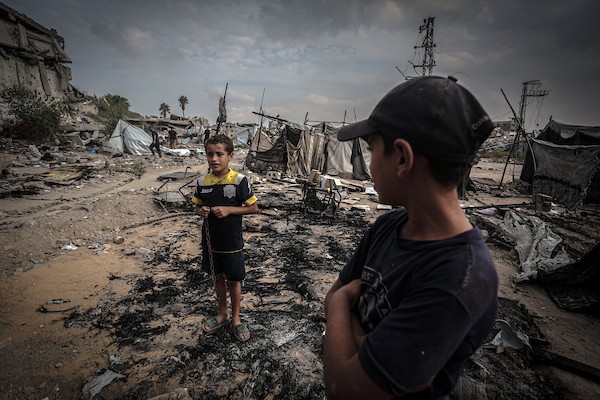 نازحون فلسطينيون يتفقدون بقايا خيامهم وممتلكاتهم التي أتت عليها النيران إثر غارة إسرائيلية قرب مفترق الشجاعية شرقي مدينة غزة، 26 أكتوبر 2026. (تصوير: بلال أسامة)