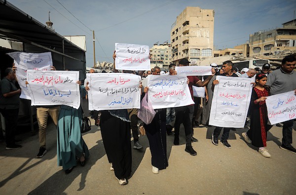 موظفون ولاجئون فلسطينيون يشاركون في مسيرة نظمها اتحاد الموظفين العرب بالأونروا من ساحة الكتيبة إلى المكتب الإقليمي للوكالة بمدينة غزة، للمطالبة بحماية حقوق العاملين واستمرار خدمات اللاجئين، 26 أكتوبر 2026. (تصوير: محمد صالحة)