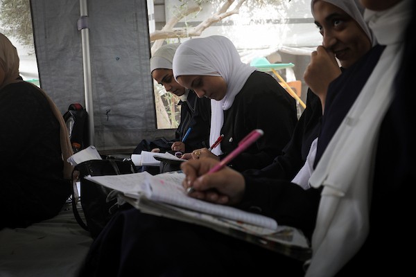 طالبات يتابعن دروسهن داخل خيام تعليمية مؤقتة في مخيم البريج وسط قطاع غزة، استعدادًا لامتحانات المرحلة الثانوية، في 13 أكتوبر/تشرين الأول 2026. (تصوير: معز صالحي)