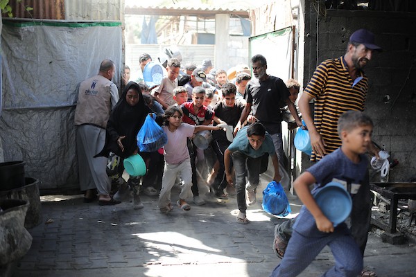فلسطينيون نازحون يتجمعون للحصول على وجبات غذائية من مطبخ خيري في مخيم النصيرات وسط قطاع غزة، في 8 أكتوبر/تشرين الأول 2026.تصوير: حسن الجدي