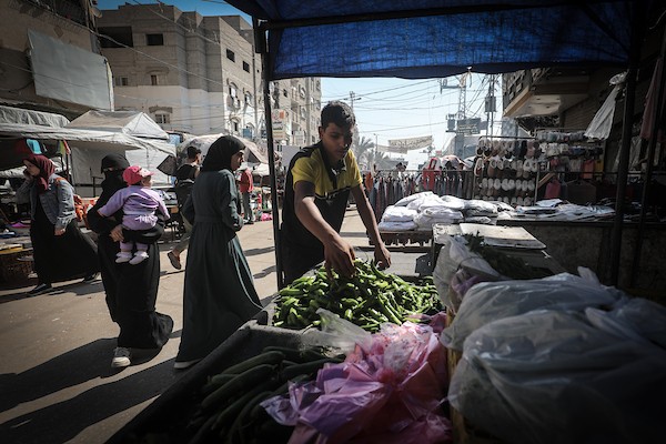 باعة فلسطينيون ومواطنون يقفون أمام أكشاك شبه خالية من الخضراوات والفواكه في أحد أسواق مخيم النصيرات وسط قطاع غزة، الخميس 22 أكتوبر 2026. تصوير: معز صالحي