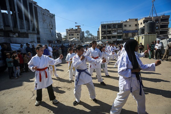 أطفال وشباب فلسطينيون، بينهم رياضيون من ذوي الإعاقة، يشاركون في عروض للكاراتيه بمدينة غزة، احتفالاً بانضمام ألف لاعب ولاعبة جدد للاتحاد الفلسطيني، 20 أكتوبر/تشرين الأول 2026.تصوير: محمد صالحة