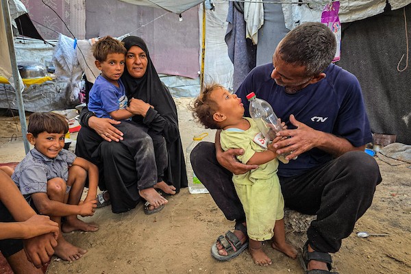 عائلات نازحة تقيم داخل خيام نُصبت بين القبور في إحدى مقابر خان يونس جنوبي قطاع غزة، في 14 أكتوبر/تشرين الأول 2026. (تصوير: طارق محمد)