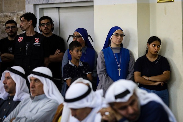 أشخاص يتجمعون خلال جنازة امرأتين مسيحيتين (أم و ابنتها) فلسطينيتين في كنيسة القديس بورفيريوس للروم الأرثوذكس في مدينة غزة، في 3 أكتوبر 2026. تصوير بلال أسامة