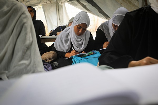 طالبات يتابعن دروسهن داخل خيام تعليمية مؤقتة في مخيم البريج وسط قطاع غزة، استعدادًا لامتحانات المرحلة الثانوية، في 13 أكتوبر/تشرين الأول 2026. (تصوير: معز صالحي)