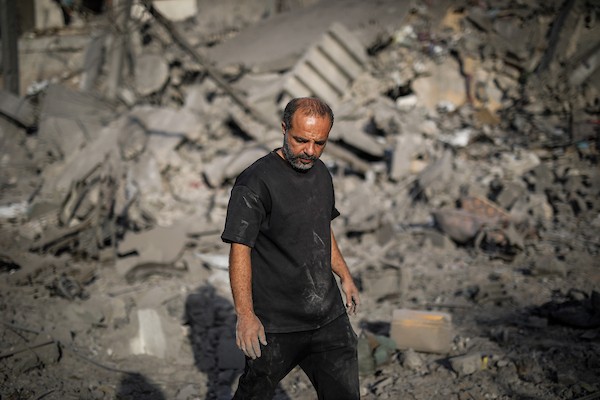 فلسطينيون يتفقدون ممتلكاتهم وسط أنقاض مبنى سكني استهدفته غارة جوية إسرائيلية في حي اليرموك بمدينة غزة، يوم 16 أكتوبر/تشرين الأول 2026. (تصوير: محمد صالحة)