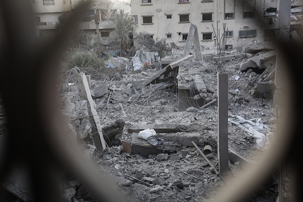 فلسطينيون يتفقدون ممتلكاتهم وسط أنقاض مبنى سكني استهدفته غارة جوية إسرائيلية في حي اليرموك بمدينة غزة، يوم 16 أكتوبر/تشرين الأول 2026. (تصوير: محمد صالحة)
