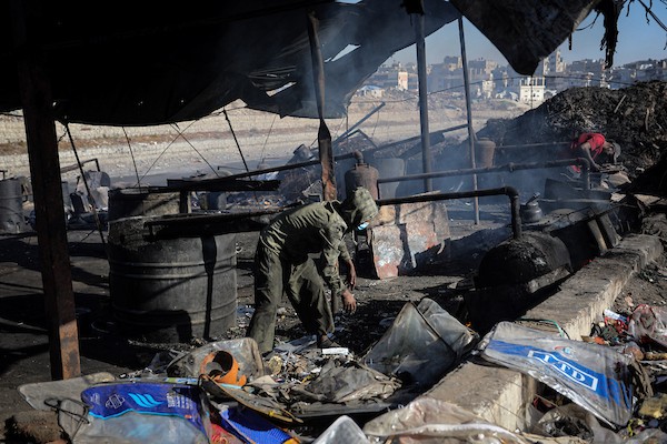 عمال فلسطينيون يجمعون ويفرزون النفايات البلاستيكية لإنتاج وقود بديل باستخدام أفران بدائية، في حي الشيخ رضوان شمال مدينة غزة، لمواجهة شح المحروقات الناجم عن الحصار الإسرائيلي، 29 أكتوبر 2026. (تصوير: محمد صالحة)