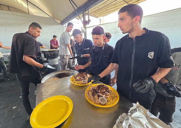يتجمع فلسطينيون نازحون لتلقي وجبات ساخنة من مطبخ خيري، يُوصف بأنه آخر مطبخ عامل في منطقة المواصي بخان يونس، 2 أكتوبر/تشرين الأول 2026. (صورة: طارق محمد)