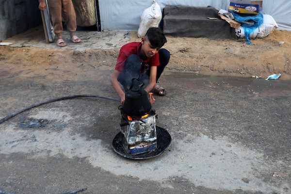 تحت أمطار غزة، يسير فلسطينيون نازحون وسط ظروف معيشية قاسية، فيما يحاول آخرون تغطية خيامهم لمنع تسرب مياه الأمطار إليها، في 18 أكتوبر/تشرين الأول 2026.تصوير: محمد صالحة