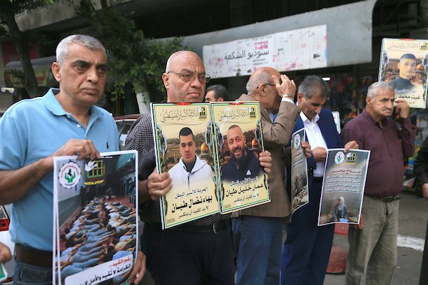 عائلات أسرى فلسطينيين ترفع صور أبنائها خلال وقفة في نابلس للمطالبة بالإفراج عنهم، وسط تحذيرات من تصاعد الانتهاكات بحق الأسرى والأسيرات في سجون الاحتلال. (تصوير: محمد ناصر)