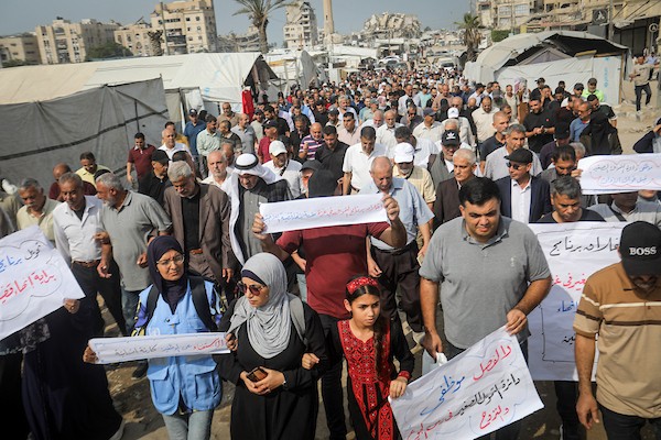 موظفون ولاجئون فلسطينيون يشاركون في مسيرة نظمها اتحاد الموظفين العرب بالأونروا من ساحة الكتيبة إلى المكتب الإقليمي للوكالة بمدينة غزة، للمطالبة بحماية حقوق العاملين واستمرار خدمات اللاجئين، 26 أكتوبر 2026. (تصوير: محمد صالحة)