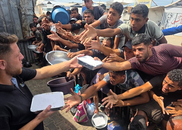يتجمع فلسطينيون نازحون لتلقي وجبات ساخنة من مطبخ خيري، يُوصف بأنه آخر مطبخ عامل في منطقة المواصي بخان يونس، 2 أكتوبر/تشرين الأول 2026. (صورة: طارق محمد)