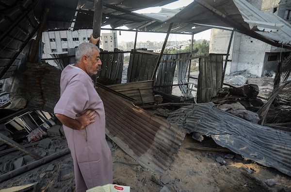 فلسطينيون يتفقدون ممتلكاتهم وسط أنقاض مبنى سكني استهدفته غارة جوية إسرائيلية في حي اليرموك بمدينة غزة، يوم 16 أكتوبر/تشرين الأول 2026. (تصوير: محمد صالحة)