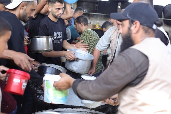 فلسطينيون نازحون يتجمعون للحصول على وجبات غذائية من مطبخ خيري في مخيم النصيرات وسط قطاع غزة، في 8 أكتوبر/تشرين الأول 2026.تصوير: حسن الجدي