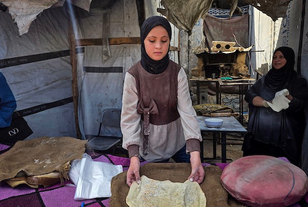 الفلسطيني مازن الدوش يُعدّ الخبز على صاج بدائي بين أنقاض المباني المدمرة في خان يونس، جنوب قطاع غزة، 9 تشرين الأول/أكتوبر 2026. (تصوير: طارق محمد)